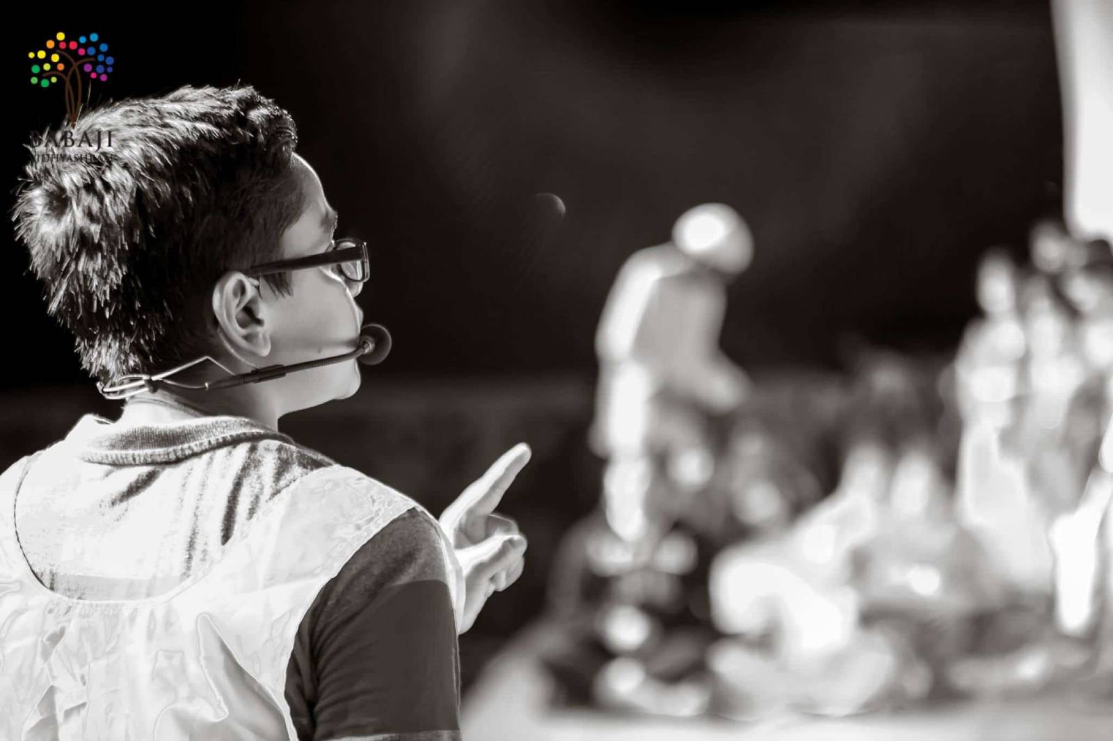 A small boy with a mini microphone is giving speech to a wide audienc on a stage in the best cbse school in Chennai.